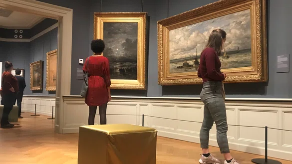 Bezoekers in een museumzaal kijken naar kunst tijdens de actie boost you mind