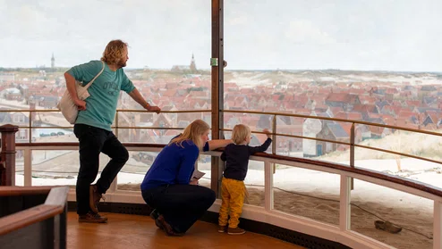 Ouders met kind kijken naar het Panorama van Scheveningen.
