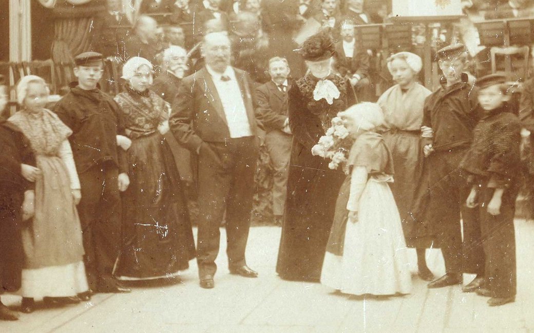 Echtpaar Mesdag tijdens hun huwelijksjubileum feest in Pulchri, omringd door kinderen in klederdracht.