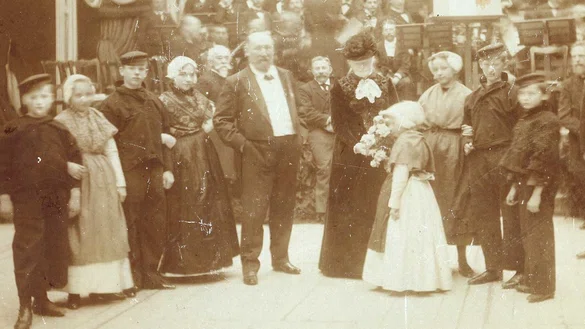 Echtpaar Mesdag tijdens hun huwelijksjubileum feest in Pulchri, omringd door kinderen in klederdracht.