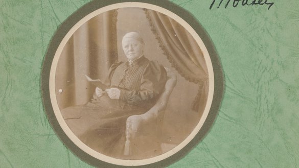 Sientje Mesdag-van Houten in stoel met boek in de hand, foto in rond kader.