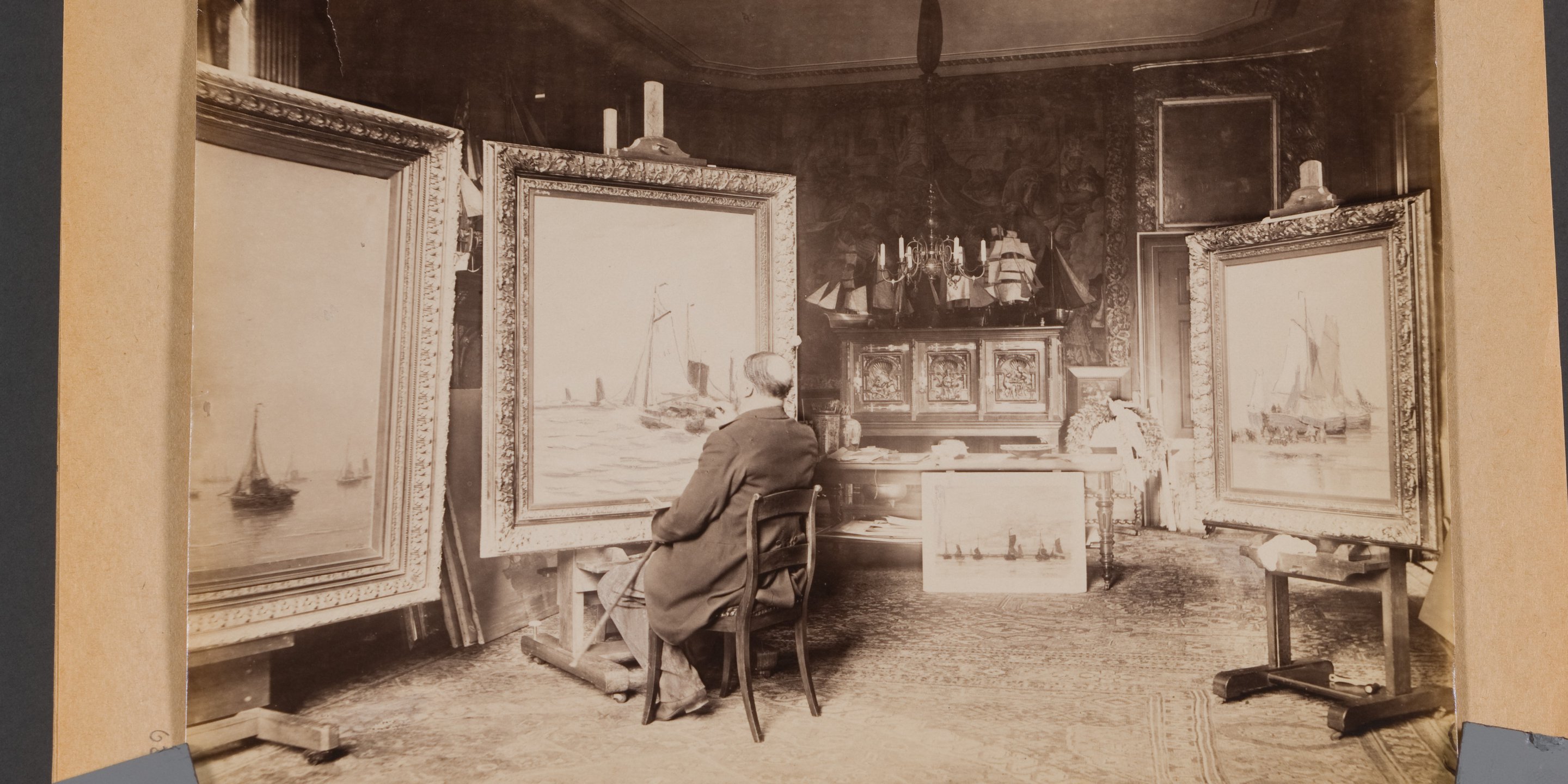 Hendrik Willem Mesdag zittend op een stoel, aan het werk in zijn atelier.